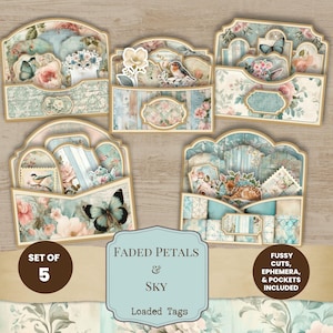 May include: A set of five decorative paper pockets and tags featuring floral patterns, butterflies, birds, and a cat. The text reads: SET OF 5, FADED PETALS & SKY, FUSSY CUTS, EPHEMERA, & POCKETS INCLUDED, LOADED TAGS. The designs use soft blue and pink tones.