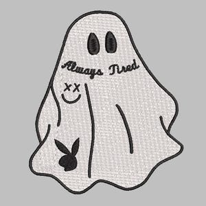 Może przedstawiać: Haftowana naszywka przedstawiająca białego ducha z czarnymi konturami. Duch ma owalne oczy, uśmiechniętą twarz z przekreślonymi oczami i logo królika. Tekst "Always Tired" znajduje się nad twarzą.