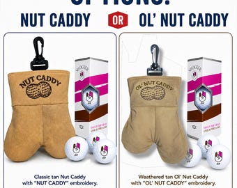May include: A tan pouch with a black clip and embroidered text reading NUT CADDY or OL' NUT CADDY, accompanied by white golf balls featuring a hand graphic and the number 69. The set includes a tall box with pink and brown stripes and the text SHOCKER.