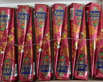 May include: A collection of twelve Kaveri Mehendi cones arranged in a box. Each cone is wrapped in shiny pink metallic foil with blue and gold labels featuring the brand name Kaveri, text, and a small green leaf graphic on the front.