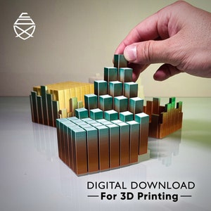 Puede incluir: Una mano coloca un pequeño bloque de color verde azulado y bronce sobre una estructura impresa en 3D. La estructura está compuesta por numerosos bloques rectangulares, con otros en tonos dorados y verdes. Incluye el texto "DIGITAL DOWNLOAD - For 3D Printing".
