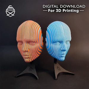 Puede incluir: Dos esculturas de cabeza humana impresas en 3D, una naranja y otra azul, cada una montada sobre un soporte negro. Las cabezas están construidas con tiras horizontales en capas. Se muestra el texto "DIGITAL DOWNLOAD - For 3D Printing".