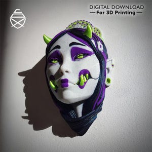 Może przedstawiać: Maska wydrukowana w 3D z wystylizowaną twarzą. Ma białą skórę, fioletowe akcenty oraz zielone rogi i zęby. Maska ma czarne włosy z fioletowymi pasemkami. Tekst brzmi "POBIERANIE CYFROWE - Do druku 3D".