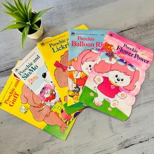 May include: A collection of vintage children's books featuring the character Poochie. The books have colorful covers with illustrations of Poochie in various scenarios. Titles include "Poochie and SloMo" and "Poochie Flower Power". The books are in good condition.