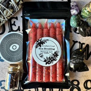 May include: A package of red hex breaking spell candles with a white label that reads "Occulture Crypt Hex Breaking Witchmade Spell Candles".