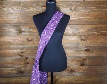 May include: Purple fabric bag with white polka dots. The bag is shown hanging on a black mannequin against a wood background.