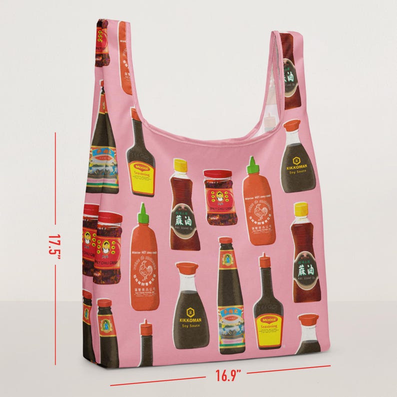 May include: Pink reusable shopping bag with a pattern of various Asian sauces and condiments. The bag is 17.5 inches tall and 16.9 inches wide. The bag features images of soy sauce, chili sauce, and other Asian cooking staples.