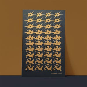 May include: A black rectangular art print featuring a repeating pattern of gold starburst shapes that transition into abstract forms. The text "STARKEEP STUDIO" is printed in white at the bottom.