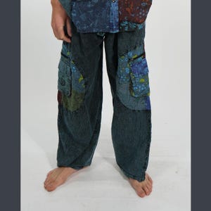 Peut inclure: Pantalon cargo ample en jean délavé à l'acide foncé, doté de grandes poches latérales avec des empiècements en tissu à motifs bleus et verts. Le pantalon présente une coupe large et est composé d'un mélange de jean uni et de tissu à fleurs.