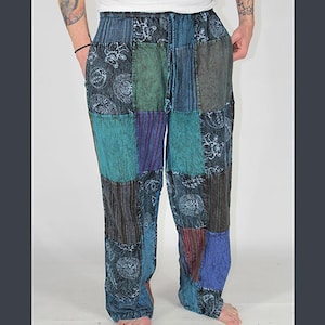 May include: Patchwork pants in shades of blue, green, and purple. The pants feature a drawstring waist and a relaxed fit. The fabric has a mix of patterns, including floral and striped designs. The pants are made of a soft, lightweight material.
