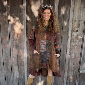 May include: A patchwork jacket in shades of brown, red, and tan with a full-length zipper and pockets. The jacket has a unique, textured design and is worn with tan boots. The style is bohemian and casual.