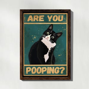 Puede incluir: Un p&oacute;ster de estilo vintage con un gato blanco y negro con el texto "Are you pooping?" en amarillo.