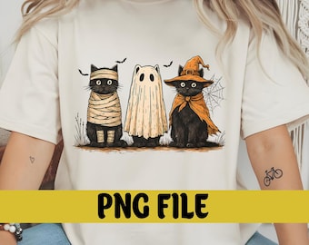 May include: A cream-colored t-shirt featuring three black cats dressed in Halloween costumes. One cat is wrapped as a mummy, another is a ghost, and the third wears a witch hat and cape. The text "PNG FILE" is displayed on a yellow banner.