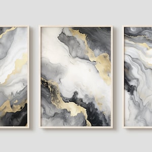 May include: Three framed abstract art prints with a white background and black and gold swirling patterns.