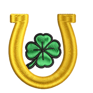 Puede incluir: Una herradura dorada con un trébol de cuatro hojas verde en el centro.