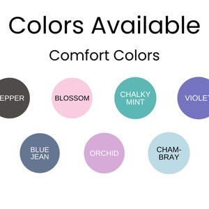 Op de afbeelding: Afbeelding met een kleurenpalet met de tekst "Colors Available" en "Comfort Colors". Het palet bevat cirkelvormige kleurstalen in tinten als peper, blossom, krijtmunt, violet, blue jean, orchidee en chambray. Het Foxy Finds-logo staat rechtsonder.