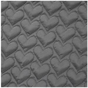 May include: Close-up of a gray quilted fabric with a repeating heart pattern. The hearts are stitched onto the fabric, creating a textured surface. The fabric is a solid gray color.
