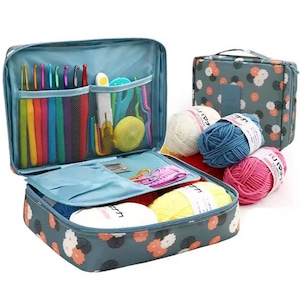 May include: A blue floral patterned craft organizer with multiple compartments, filled with colorful crochet hooks, yarn, and other craft supplies. Includes a matching tote bag and several balls of yarn in white, blue, and pink.