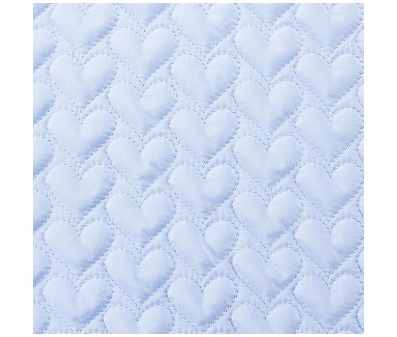 May include: A light blue quilted fabric with a repeating heart pattern. The hearts are stitched onto the fabric, creating a textured surface. The overall design is soft and romantic, suitable for bedding or decorative items.