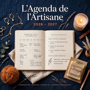 以下が含まれることがあります： L'Agenda de l'Artisane 2026-2027と題された開いた手帳。手書きの週間タスク、オレンジ色の毛糸玉、金のジュエリー、火のついたキャンドル、乾燥ラベンダー、Savon Lavande Fait Mainと書かれた紙で包まれた石鹸が配置されている。