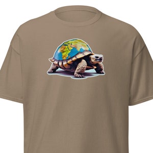 Könnte beinhalten: Ein braunes T-Shirt mit einem Aufdruck einer Schildkröte, die die Erde auf ihrem Rücken trägt.
