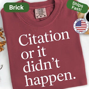 May include: Brick-colored t-shirt with the text "Citation or it didn't happen" in white. The shirt has a crew neck and short sleeves. The tag reads "Comfort Colors". The shirt is made in the USA.