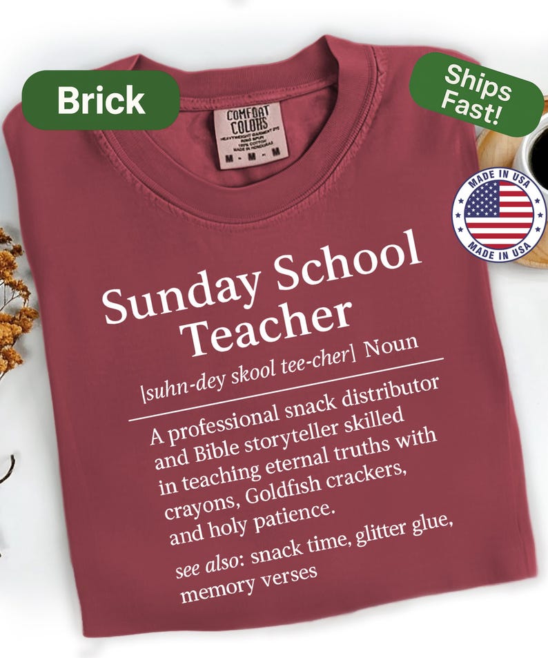 K&ouml;nnte beinhalten: Ziegelrotes T-Shirt mit wei&szlig;em Text "Sunday School Teacher". Die Definition beinhaltet "professioneller Snack-Verteiler" und "Bibel-Erz&auml;hler". Mit "Made in USA" Emblem und "Ships Fast!" Aufkleber.