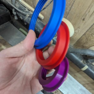 May include: Three plastic rings, one blue, one red, and one purple, stacked on top of each other.
