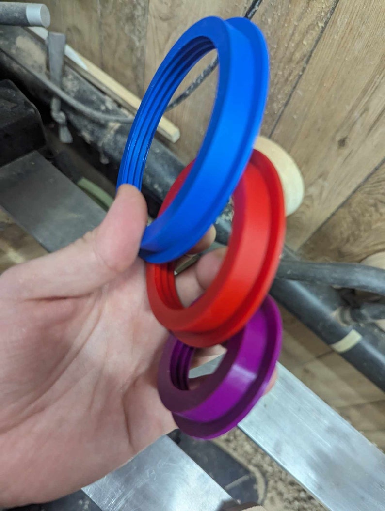 May include: Three plastic rings, one blue, one red, and one purple, stacked on top of each other.