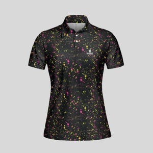 Front view of a black women's polo shirt with yellow and pink paint splatter pattern.