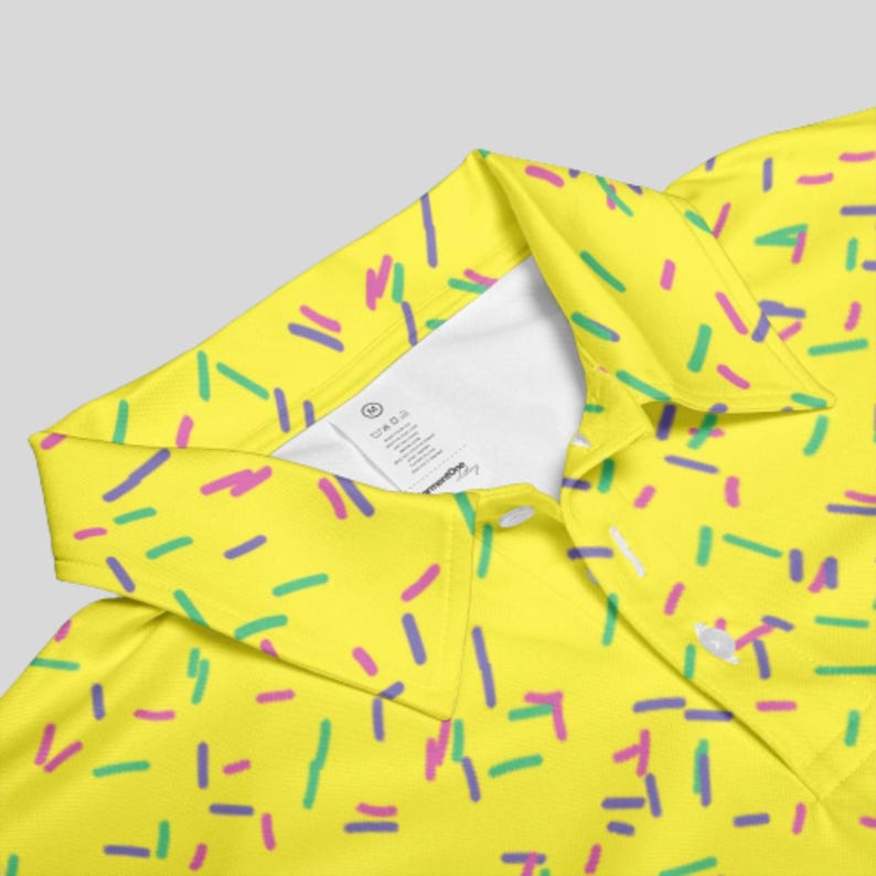 Close-up view of the collar and white inner label of the yellow sprinkle polo shirt.