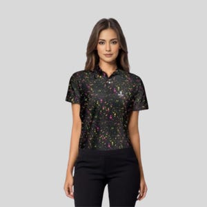 Upper body view of a female model facing forward, wearing the black paint splatter polo shirt and black trousers.