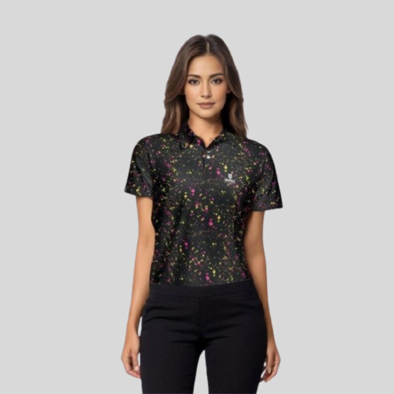Upper body view of a female model facing forward, wearing the black paint splatter polo shirt and black trousers.
