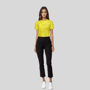 Full-body view of a model wearing the yellow patterned golf polo shirt, black pants, and white shoes.
