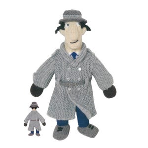 May include: A knitted figure of a cartoon detective in a gray coat, hat, and blue tie. The figure has a light skin tone, black hair, and a small belt. A smaller version of the figure is also present.