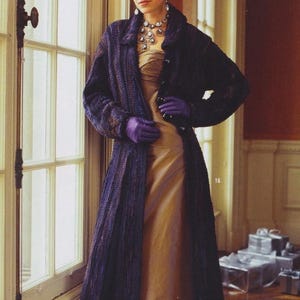 May include: A woman wearing a long, dark purple coat over a gold-colored dress. The coat has a textured appearance and is buttoned at the waist. She wears purple gloves and a statement necklace. The image includes text that reads, "From deepest damson to lilting lilac, purple provides a harmonious palette."