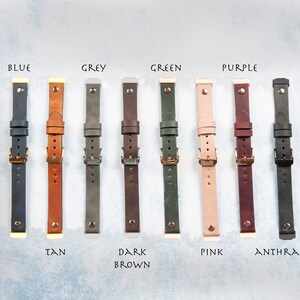 May include: A collection of leather watch straps in various colors, including blue, tan, grey, dark brown, green, pink, purple, and anthracite. Each strap features a buckle and is labeled with its color name.