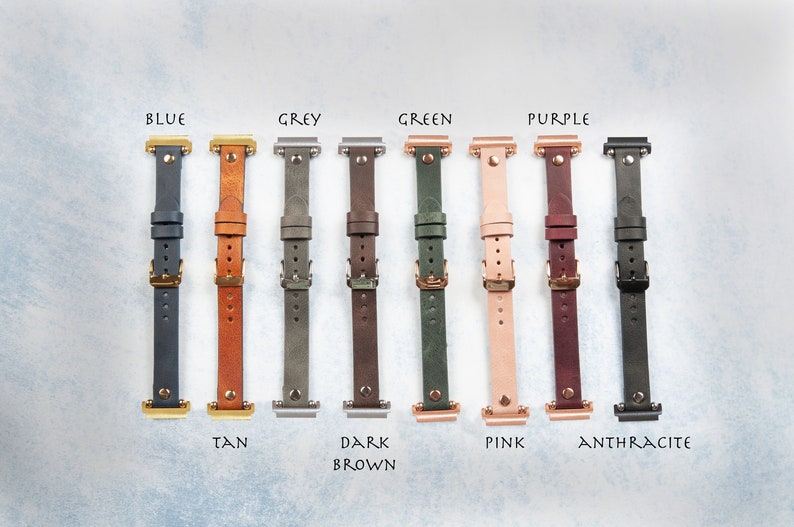 May include: A collection of leather watch bands in various colors, including blue, tan, grey, dark brown, green, pink, purple, and anthracite. Each band has a buckle and is labeled with its color name.