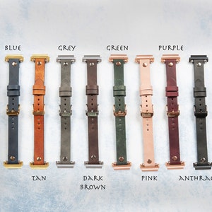 May include: A collection of leather watch bands in various colors, including blue, tan, grey, dark brown, green, pink, purple, and anthracite. Each band has a buckle and is labeled with its color name.