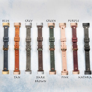 May include: A collection of leather watch straps in various colors, including blue, tan, grey, dark brown, green, pink, purple, and anthracite. Each strap features a buckle and is labeled with its color name.