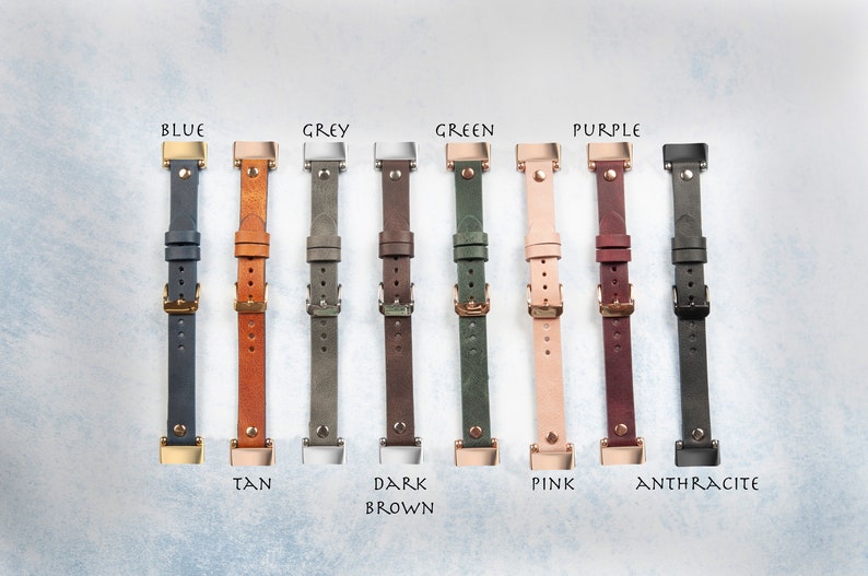 May include: A collection of leather watch straps in various colors, including blue, tan, grey, dark brown, green, pink, purple, and anthracite. Each strap features a buckle and is labeled with its color name.