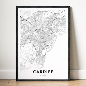 May include: Black and white map print of Cardiff, Wales. The map shows the city's streets and landmarks. The city name is printed in black at the bottom of the map.