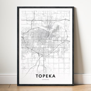 May include: Black and white map print of Topeka, Kansas in a black frame. The map shows the city streets and major roads.