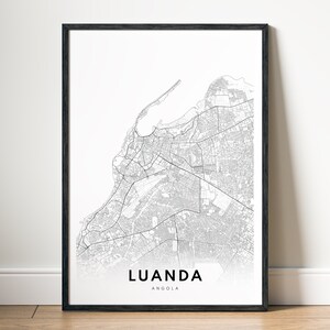 May include: A black and white map print of Luanda, Angola in a black frame. The map shows the city's streets and landmarks.