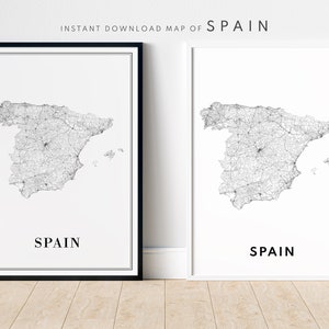 May include: Two black and white printable maps of Spain with a detailed road network. The maps are framed in black and white frames and are displayed on a light wood floor.
