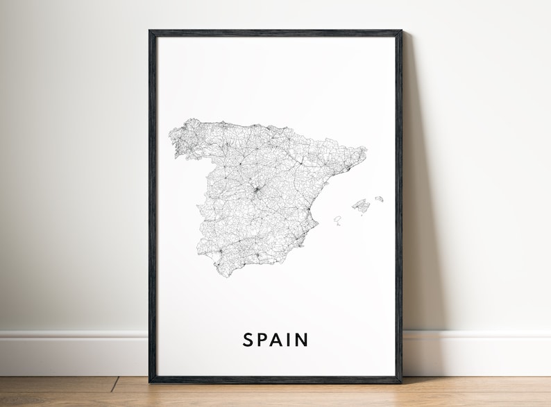 May include: A black and white line art map of Spain with the word "SPAIN" printed in black at the bottom of the map. The map is framed in a black frame.