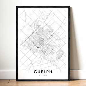 May include: A framed monochrome map print of Guelph, Ontario. The map shows the city's infrastructure, including roads and buildings. The city name and province are printed in a modern font at the bottom of the print.