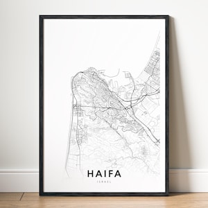 Puede incluir: Impresión enmarcada en negro que presenta un mapa detallado en blanco y negro de Haifa, Israel. El nombre de la ciudad está impreso en negrita debajo del mapa. La impresión se muestra contra una pared blanca y un suelo de madera.