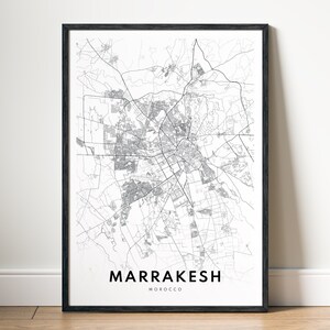 Op de afbeelding: Zwart-witte lijntekening van een kaart van Marrakesh, Marokko. De kaart toont de straten en bezienswaardigheden van de stad. De naam van de stad staat onder de kaart.