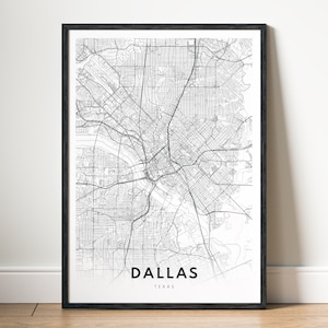 May include: A framed black and white map print of Dallas, Texas. The map details the city's streets and waterways. The city name and state are printed in a clean, modern font at the bottom of the print.